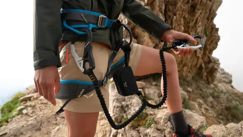 Wspinacz w uprzęży Salewa, gotowy na przygodę. Salewa co to za firma? To marka sprzętu outdoorowego, która zapewnia bezpieczeństwo w górach.