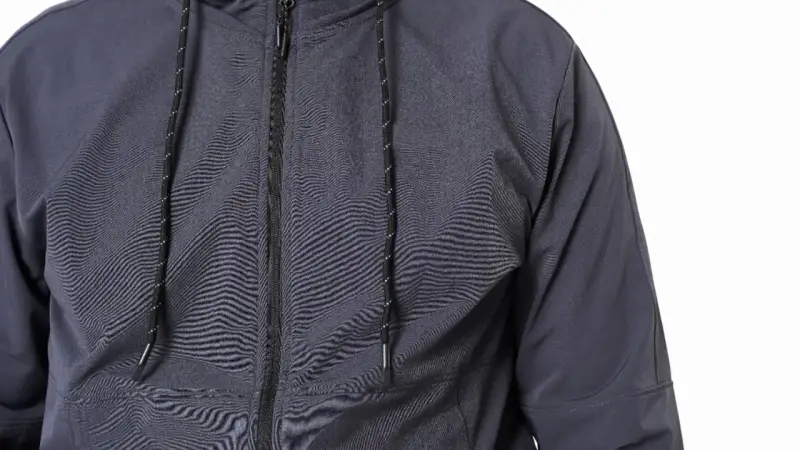 Szara kurtka softshell z zamkiem i sznurkami. Dowiedz się, jak prać softshell, by zachował swoje właściwości.
